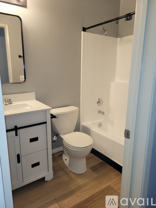 A white toilet sits next to a white sink in a bathroom.