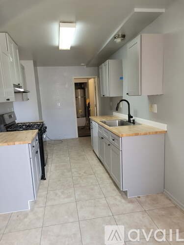 A kitchen with white cabinets and a wooden countertop.