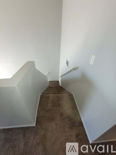 A staircase with a carpeted floor and white walls.