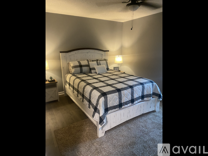 A bedroom with a bed covered in a black and white checkered comforter.