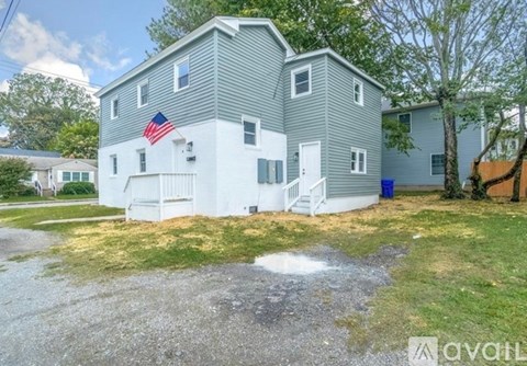 A house with a grey and white exterior and an American flag on the front.