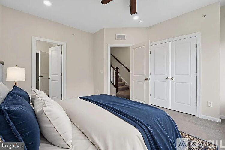 A bedroom with a bed covered in a blue blanket.