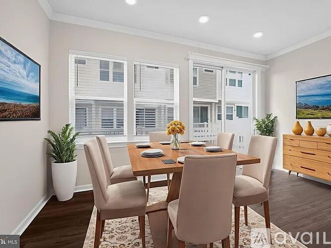 A dining room with a table set for four and a view of a building outside the window.