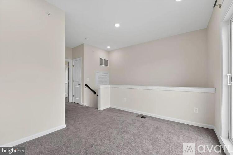 A spacious room with a carpeted floor and white walls.