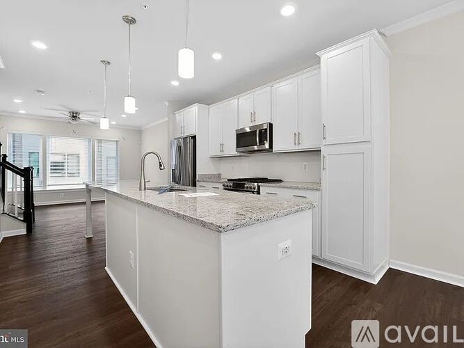 A kitchen with white cabinets and a granite countertop.