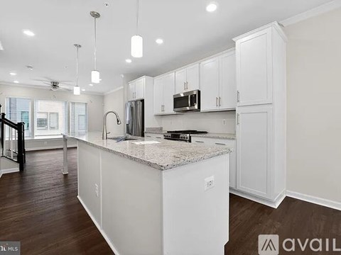 A kitchen with white cabinets and a granite countertop.