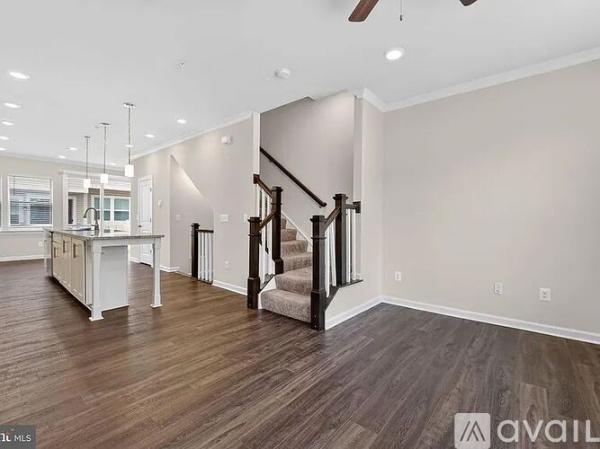 A spacious living room with a staircase leading to the upper floor.