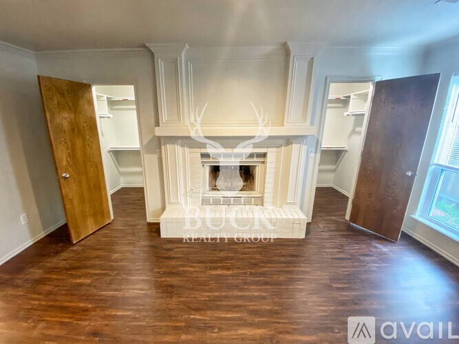 A living room with a fireplace and wooden floors.