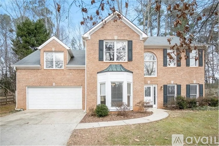 A brick house with a white garage door and a green awning.