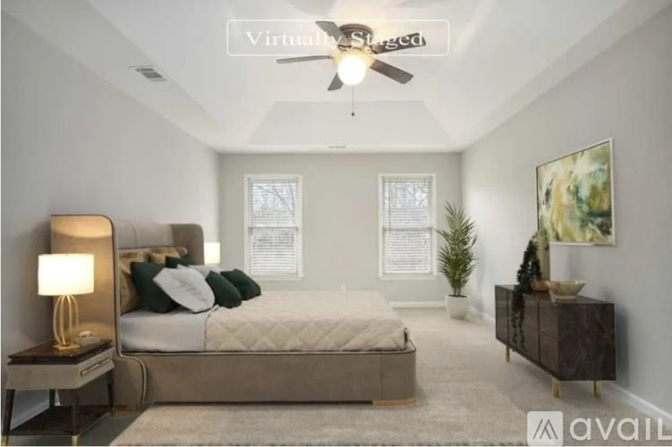A bedroom with a bed, nightstand, and a plant.
