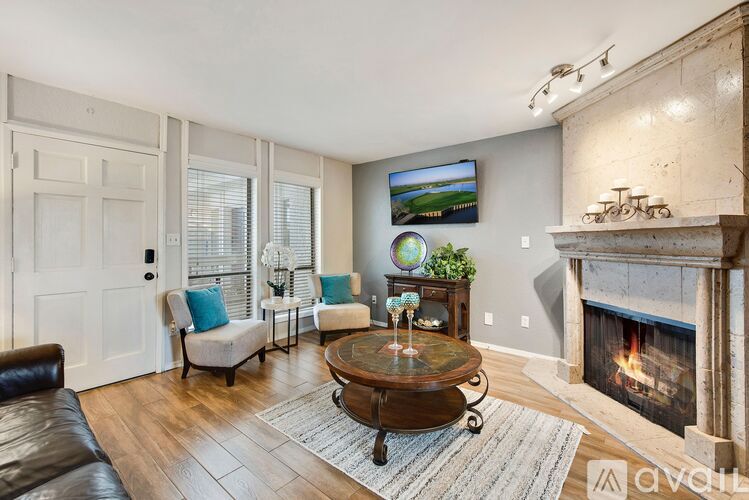 A living room with a fireplace and a painting on the wall.
