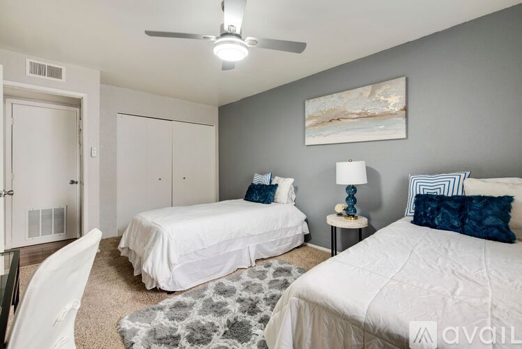 A bedroom with two beds and a ceiling fan.