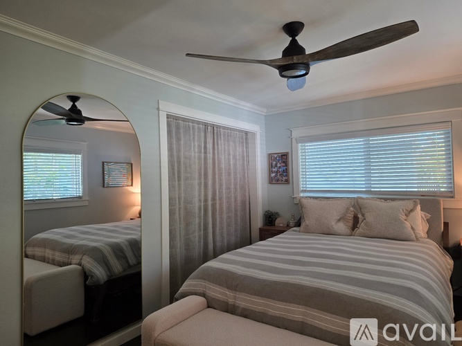 A bedroom with a large bed and a ceiling fan.