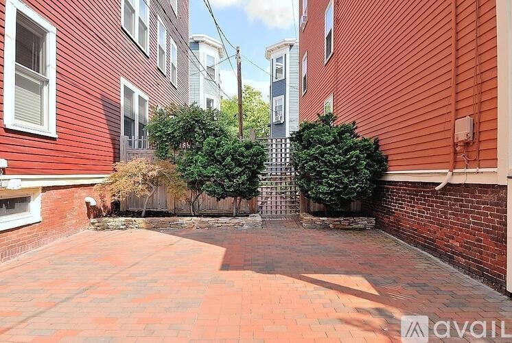 A red brick courtyard surrounded by red and blue buildings.