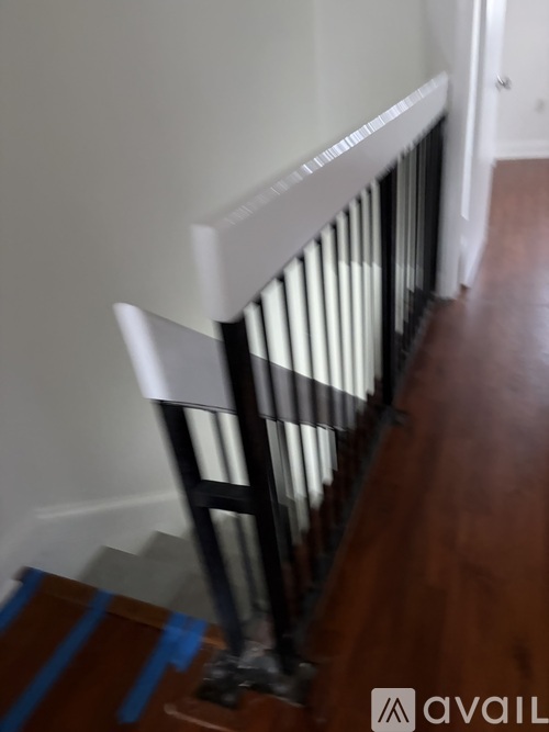 A white radiator is on a wooden floor.