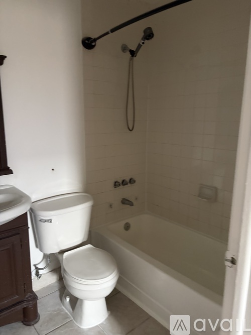 A white toilet sits next to a bathtub in a bathroom.