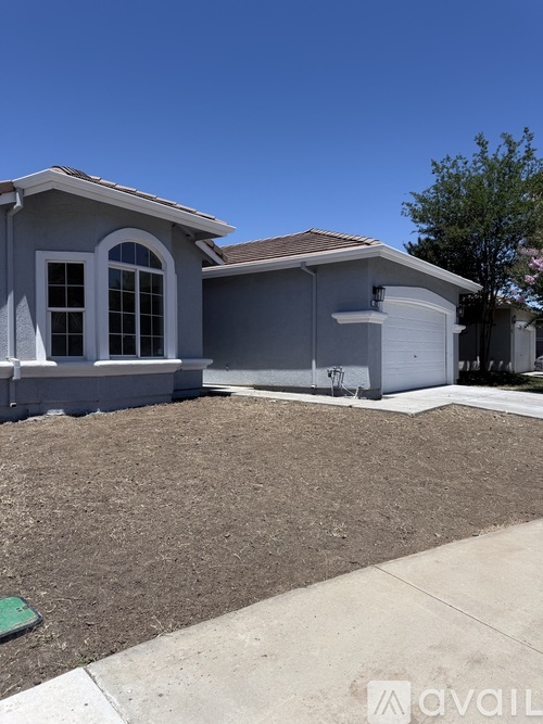 A house with a grey exterior and a brown roof.