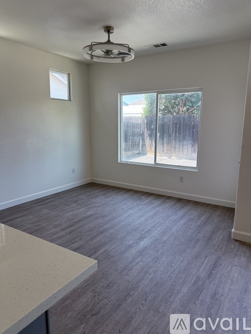 A room with a window and a fan on the ceiling.