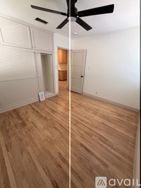 A room with wooden flooring and a ceiling fan.