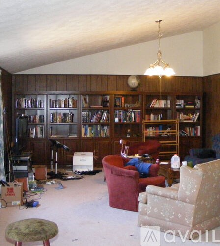 A living room with a large bookshelf and a television.