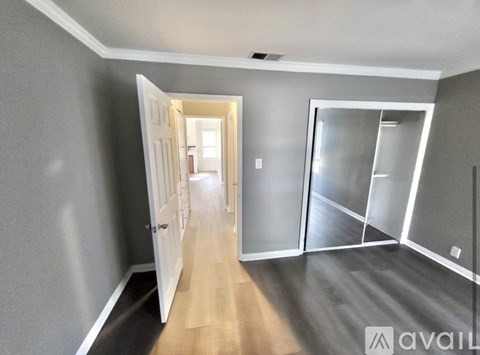 A hallway with a white door and a glass door on the right.