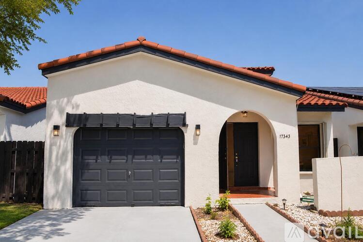 A house with a garage door and a black door.
