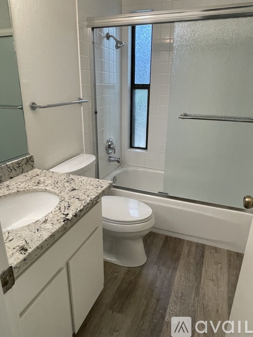 A bathroom with a toilet, sink, and shower.