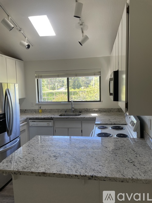 A kitchen with granite countertops and stainless steel appliances.