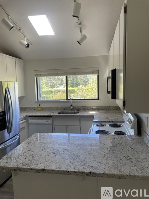 A kitchen with granite countertops and stainless steel appliances.
