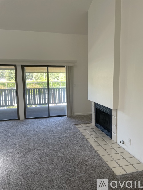 A living room with a fireplace and sliding glass doors.