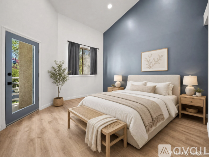 A bedroom with a bed, nightstands, and a window.