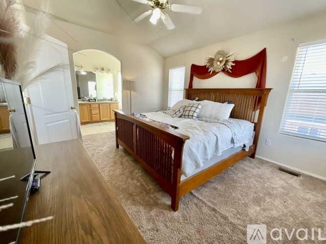 A bedroom with a large bed and a ceiling fan.