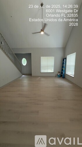 Empty room with wooden floor and a fan on the ceiling.
