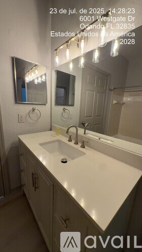 A bathroom with a sink, mirror, and lights.