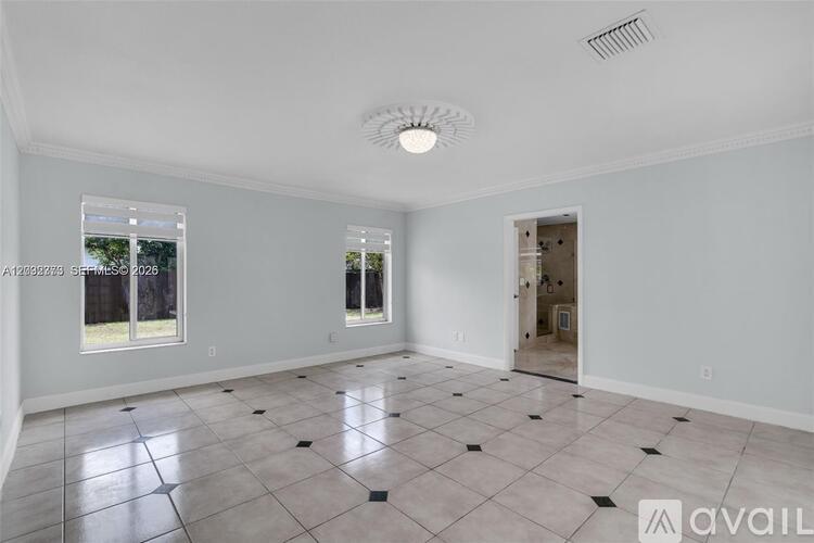 A spacious room with a tiled floor and a ceiling fan.