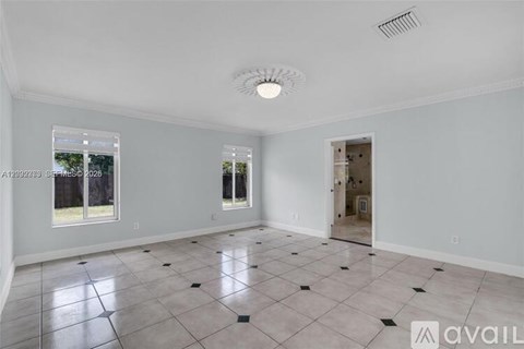 A spacious room with a tiled floor and a ceiling fan.