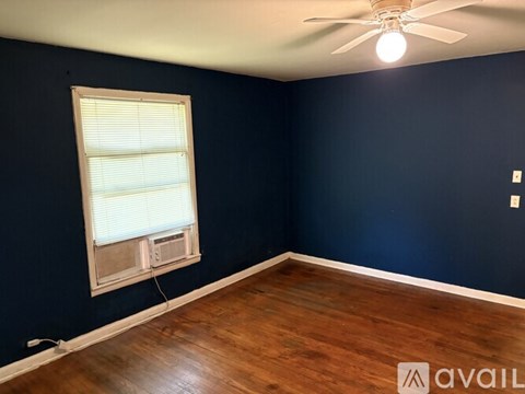A room with a ceiling fan and a window with blinds.