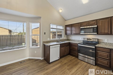 A kitchen with wooden cabinets and stainless steel appliances is available for rent.