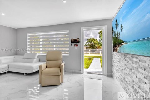 A modern living room with a chair, sofa, and a view of the beach through the window.