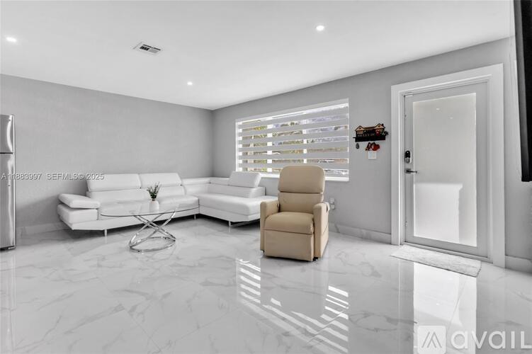 A modern living room with a white sofa and a beige armchair.