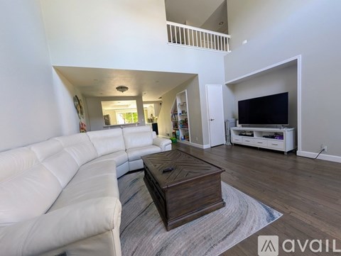 A living room with a white couch and a wooden coffee table.