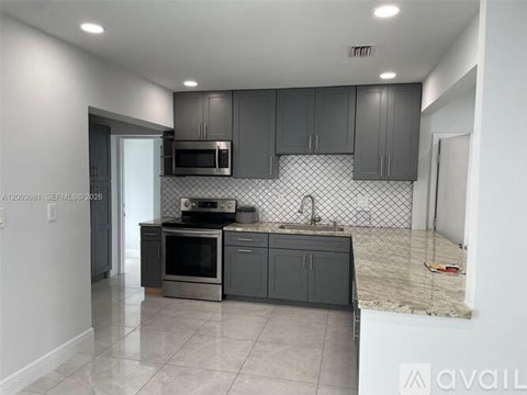 A kitchen with a microwave, oven, and sink.