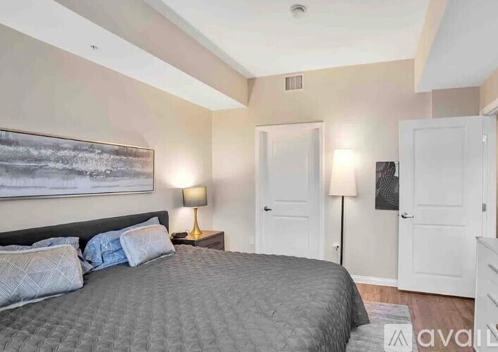 A bedroom with a large bed and two lamps.