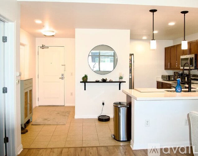 A kitchen with a white counter and a round mirror on the wall.