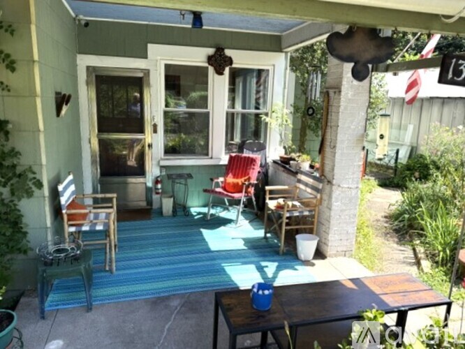 A patio with a table and chairs under a roof.