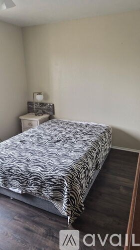 A bedroom with a bed and a nightstand.
