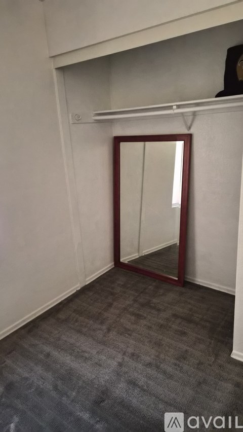 A room with a grey carpet and a red door.