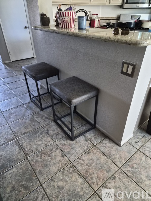Two black stools are placed in front of a kitchen counter.