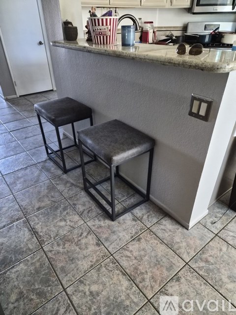 Two black stools are placed in front of a kitchen counter.