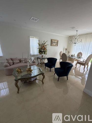 A living room with a glass coffee table and a chandelier.